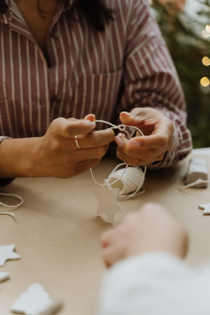 woman using string while preparing decorations for christmas